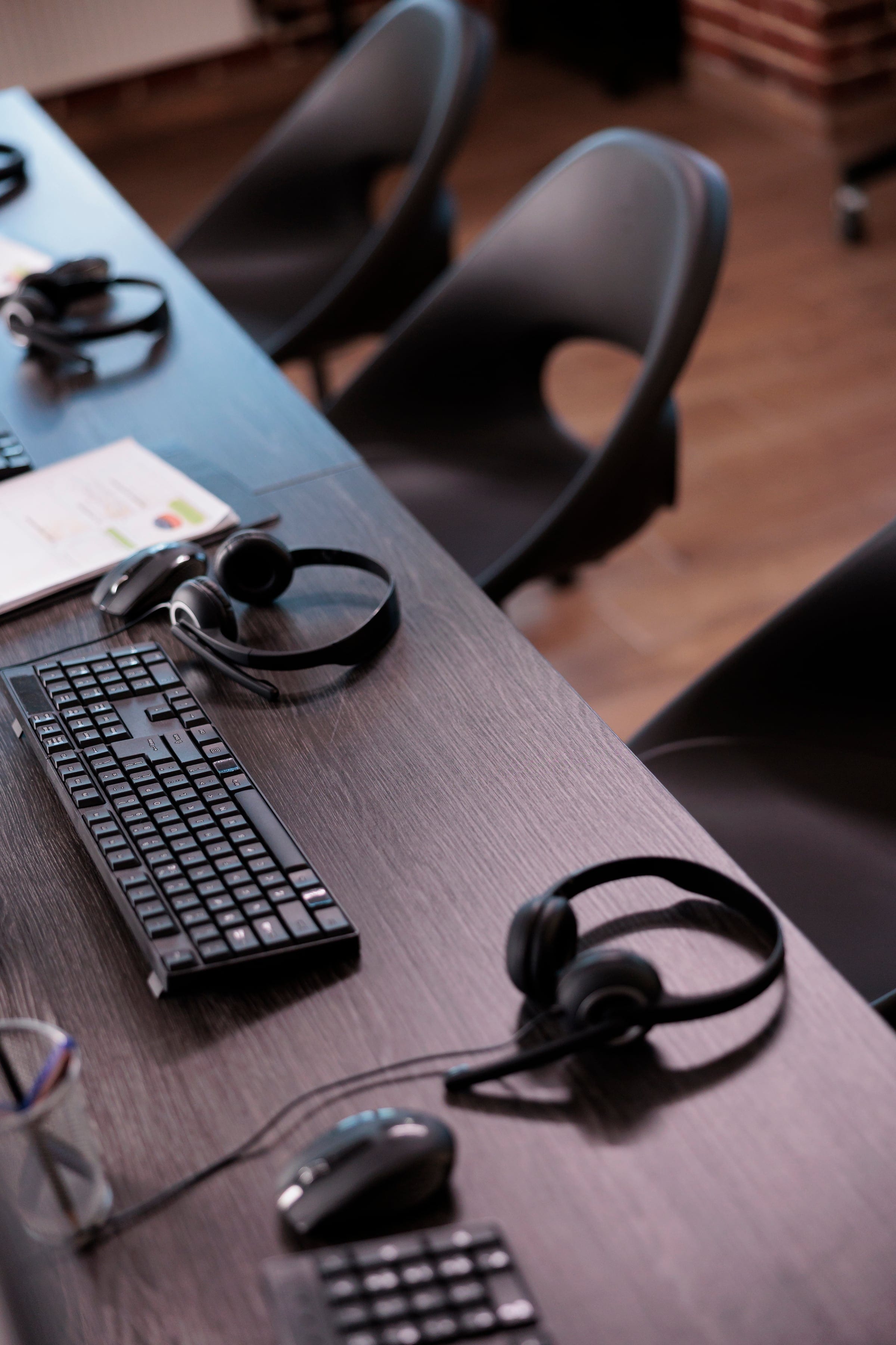 Estaciones de trabajo de call center con diademas y teclados listos para los agentes